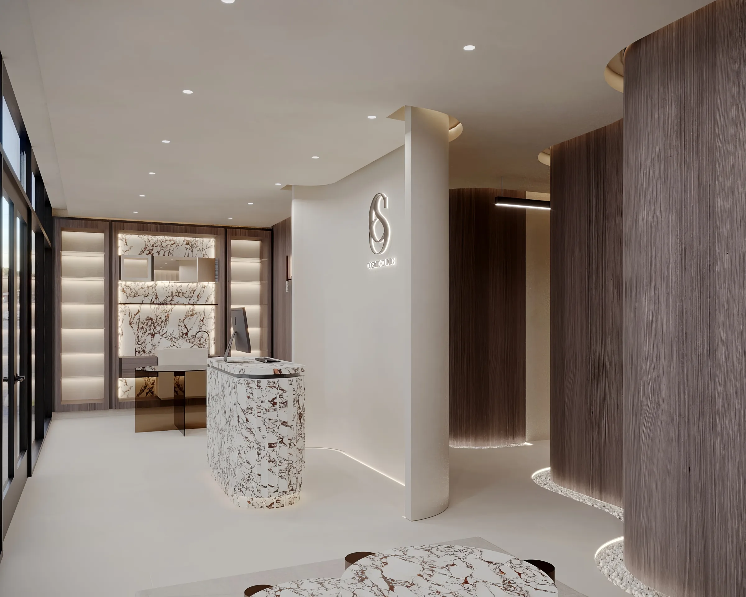Reception area with a veined stone desk, illuminated wall logo and softly curved dark timber treatment bays