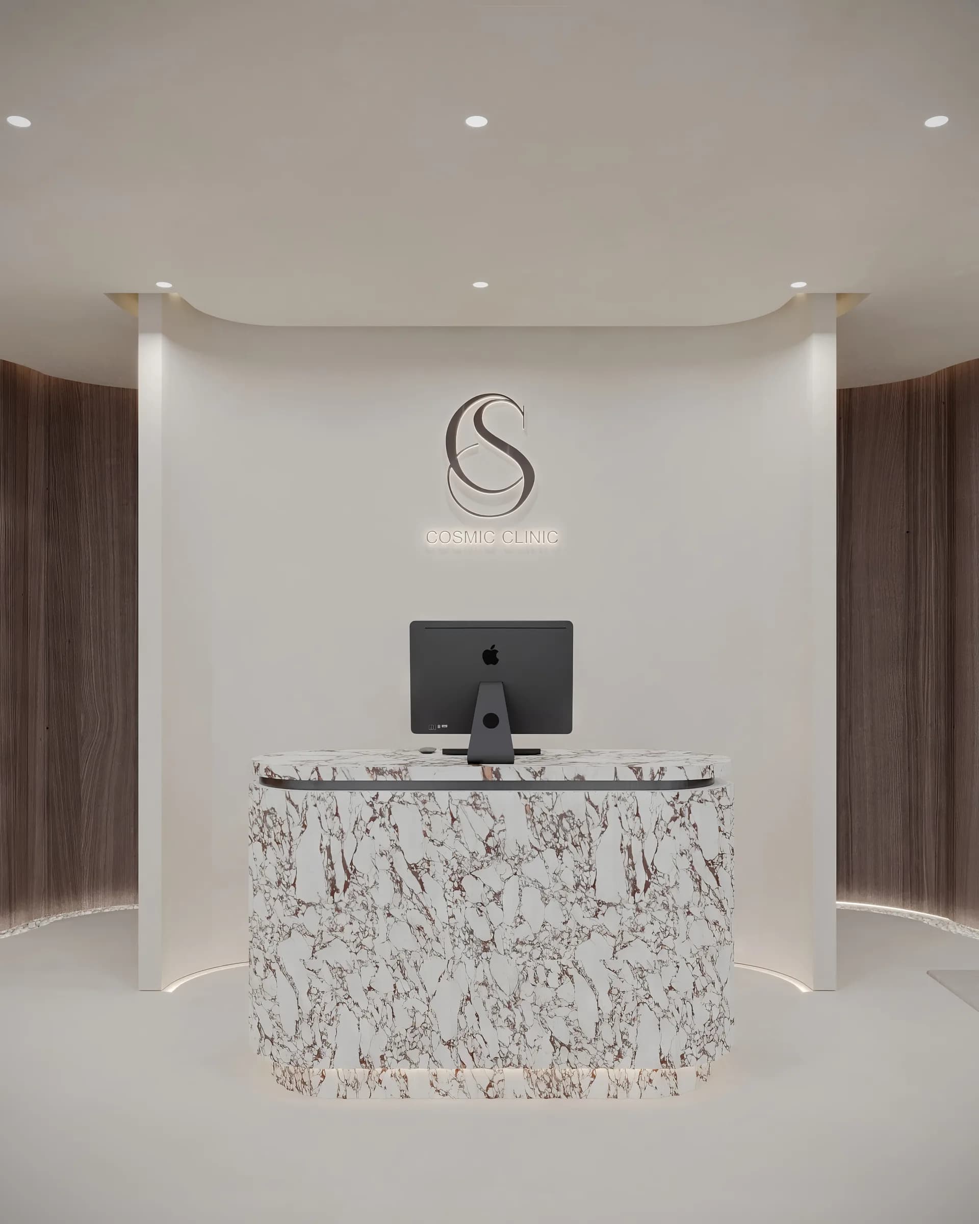 Front reception with a rounded veined stone desk, illuminated clinic logo and sweeping dark timber walls