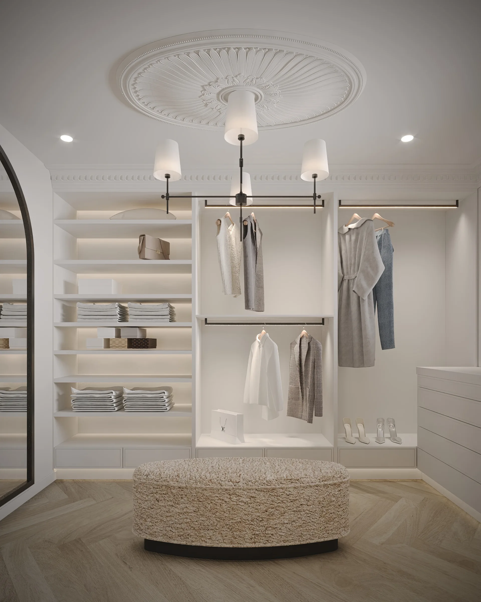 Tailored dressing room with open white shelving, black hanging rails and softly lit displays beneath a ceiling rose