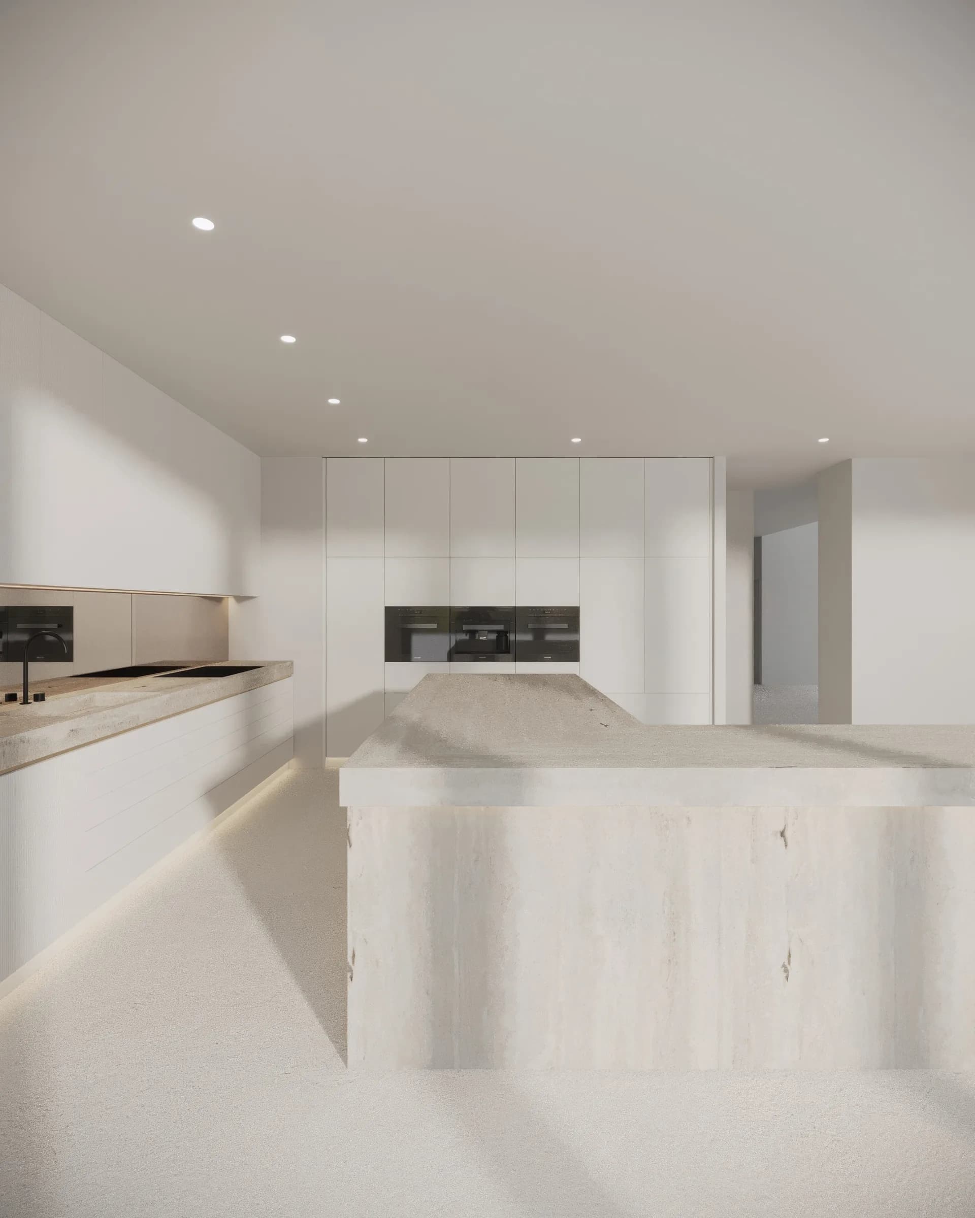 Tonal kitchen centred on a monolithic pale stone island, with handleless white cabinetry and black appliances