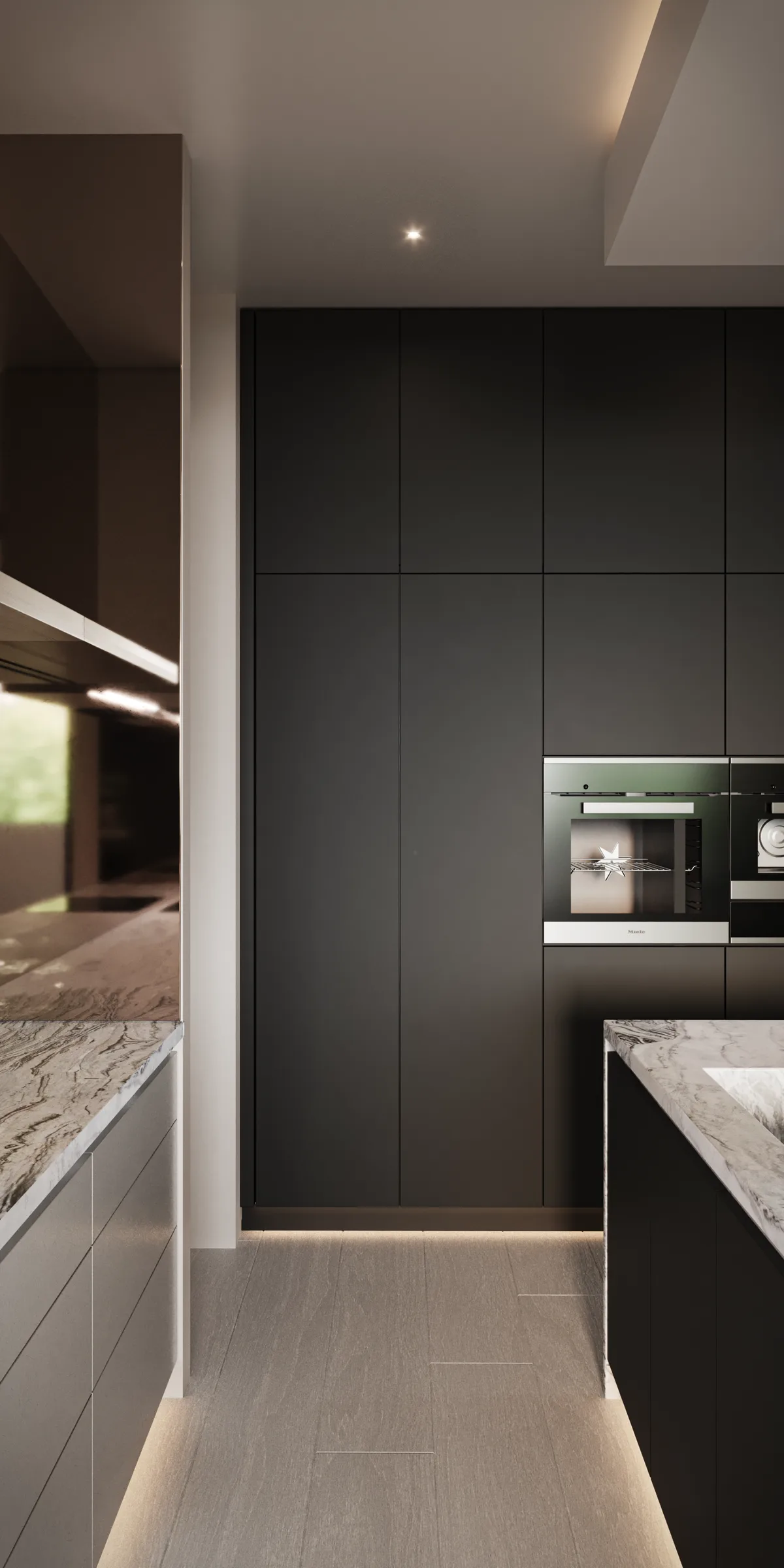Narrow kitchen passage lined with matte black cabinetry, integrated ovens and boldly veined stone worktops