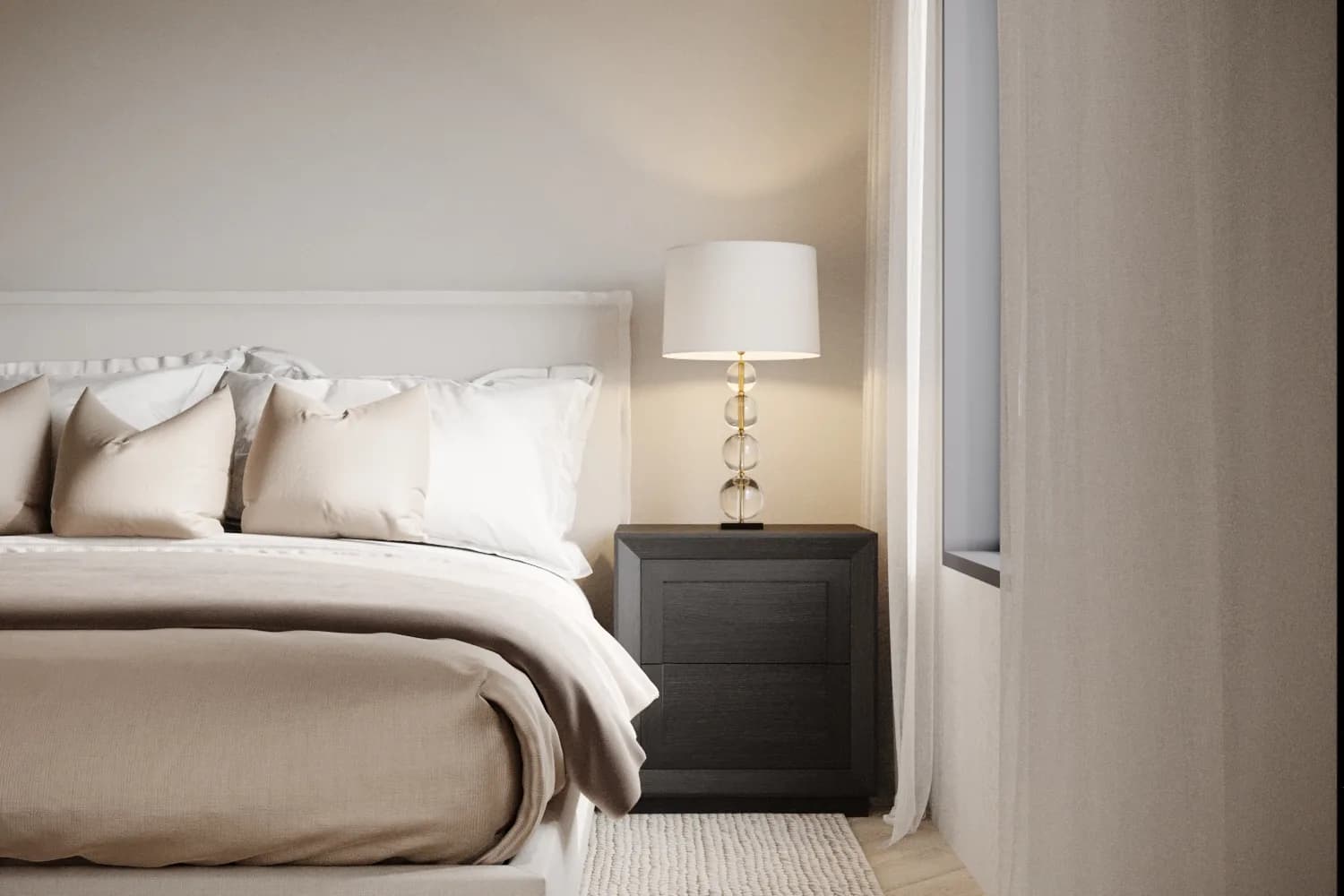 Bedroom detail with layered ivory and taupe bedding, a dark timber nightstand and a stacked glass globe lamp