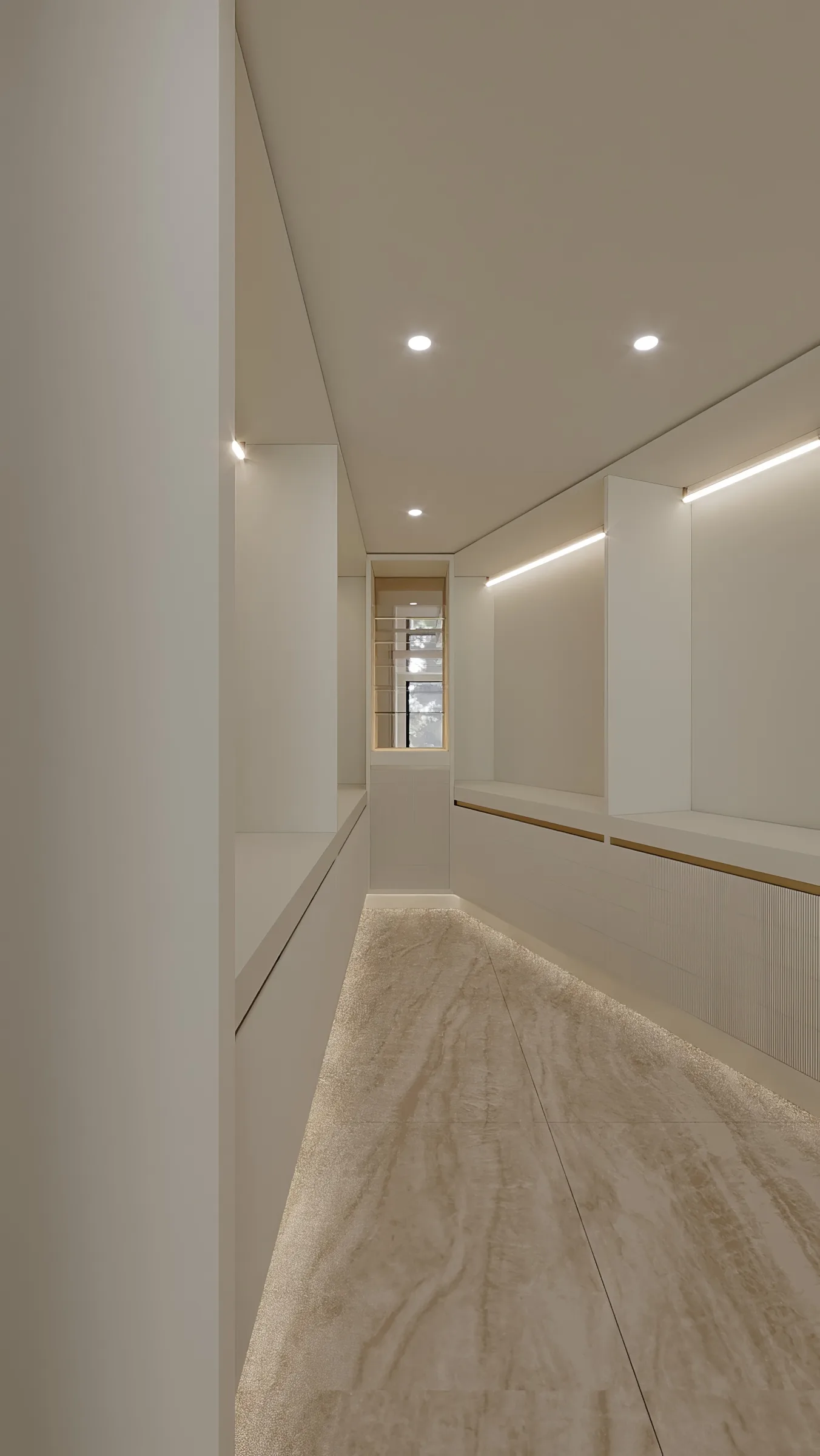 Narrow dressing room lined with ivory cabinetry, pale stone flooring and continuous under-cabinet lighting