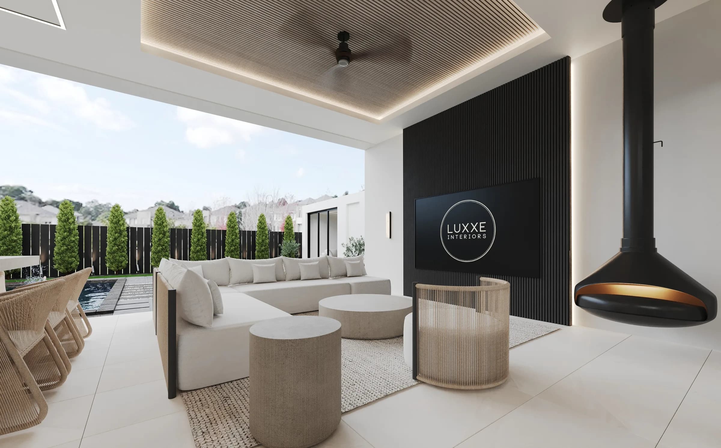 Covered poolside lounge with ivory seating, woven chairs, a black ribbed media wall and suspended fireplace