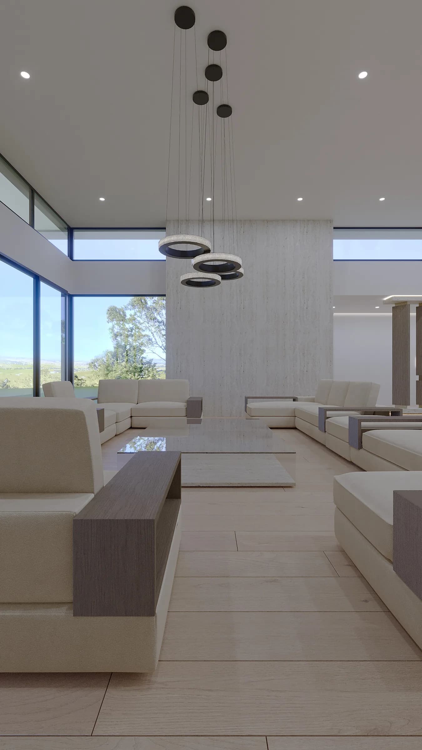 Double-height living room with cream sectional seating, pale timber floors and sculptural ring pendants before a stone wall