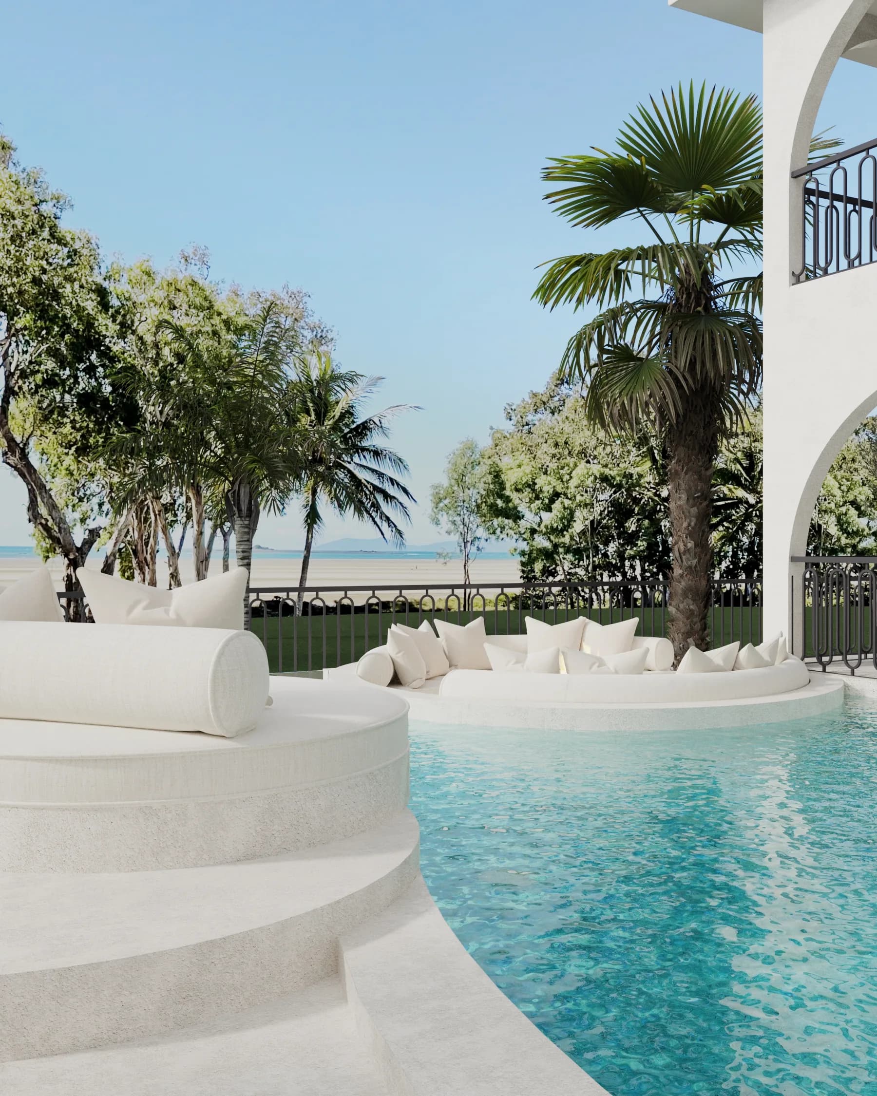 Turquoise pool curves around sculpted white in-water seating, with palms, black iron railings and an ocean outlook