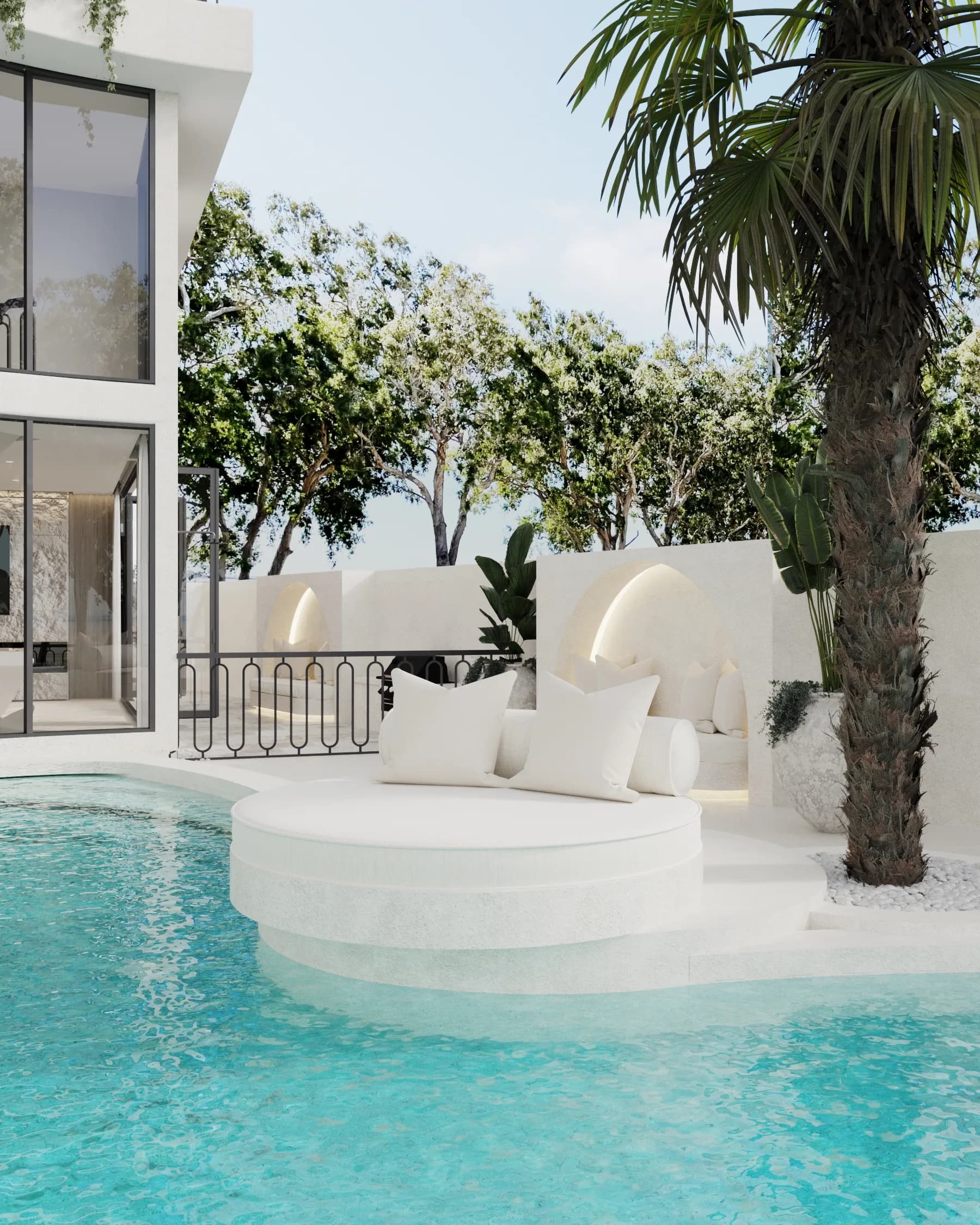 Round white pool daybed sits between illuminated stucco niches and a tall palm beside rippling turquoise water