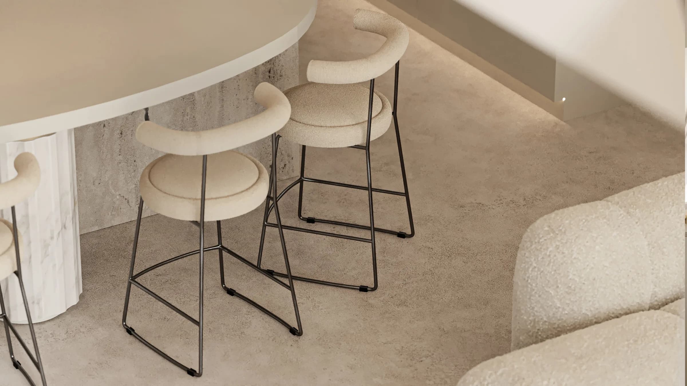 Sunlit dining and kitchen interior in warm sand tones, centred on curved furniture and a stone island