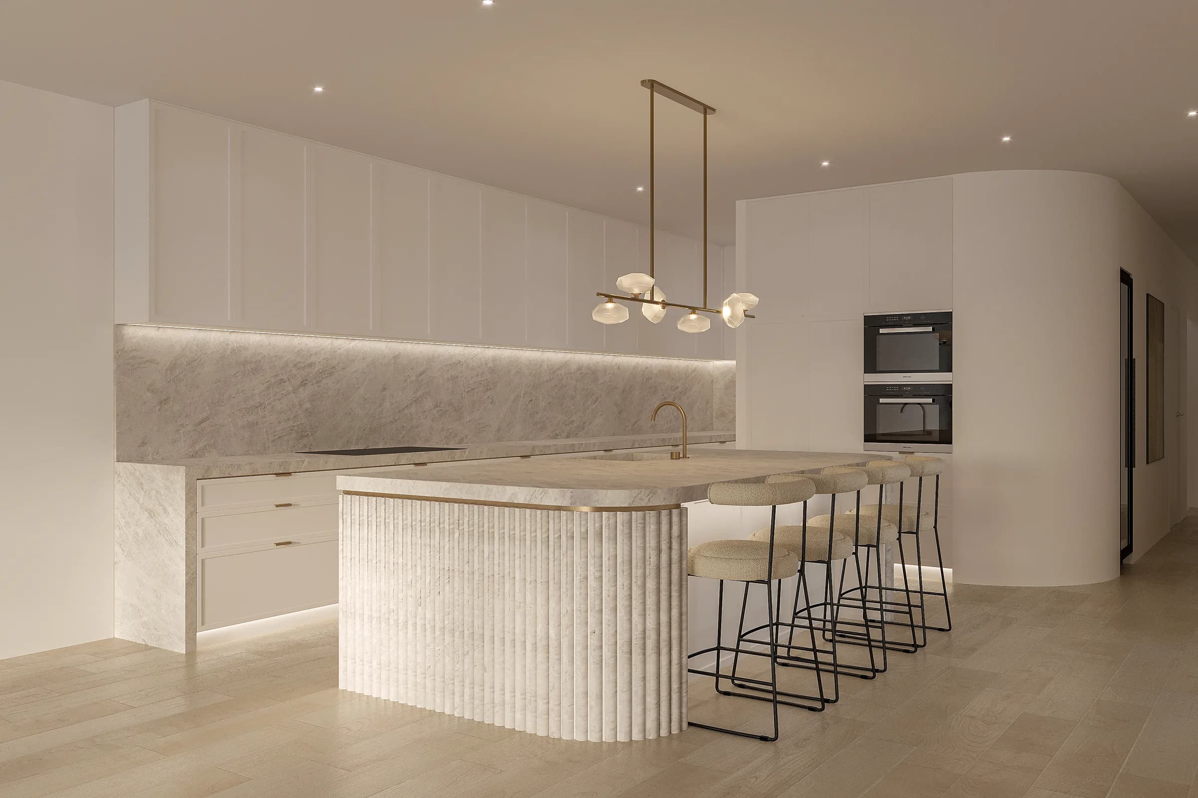 Pale-panelled kitchen with a fluted stone island, upholstered stools, brass tapware and a sculptural glass pendant